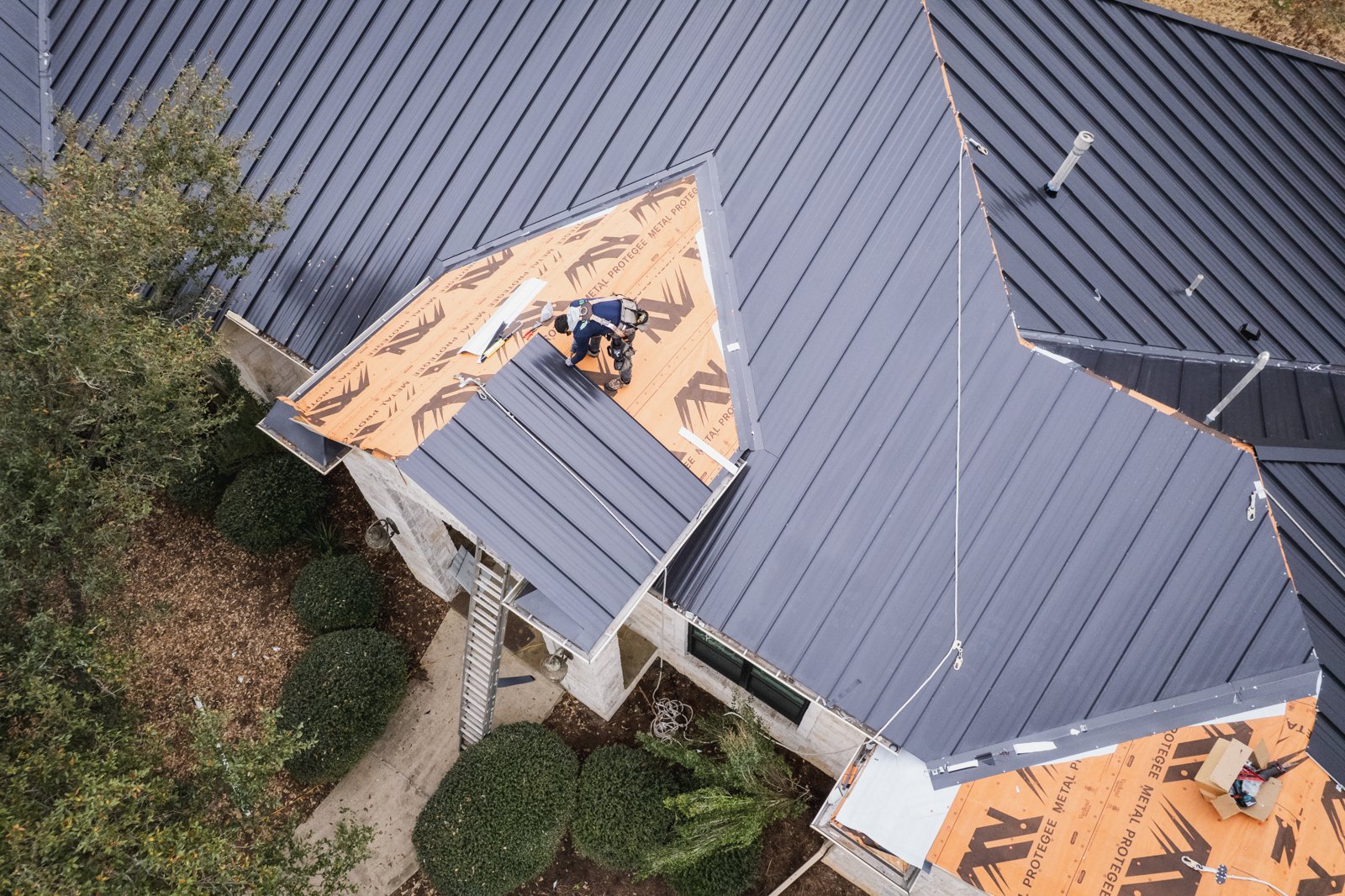 Overhead drone view of standing seam panels going over synthetic underlayment