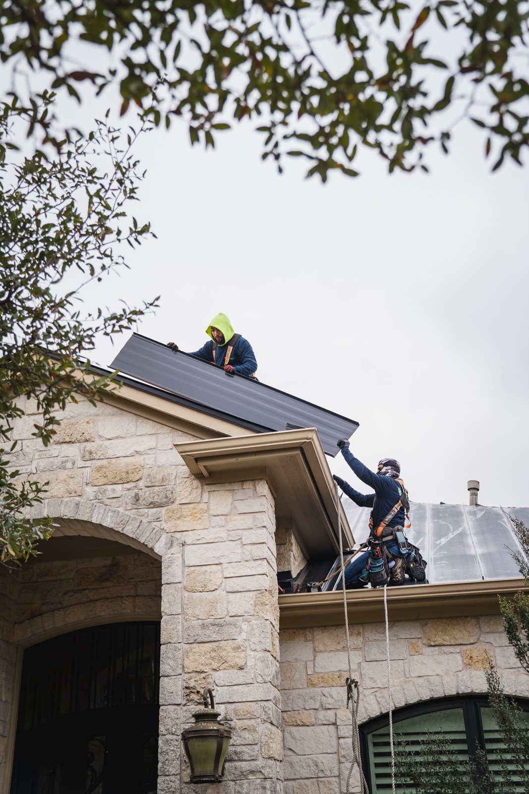 Metal panel handoff between crew members at the gable